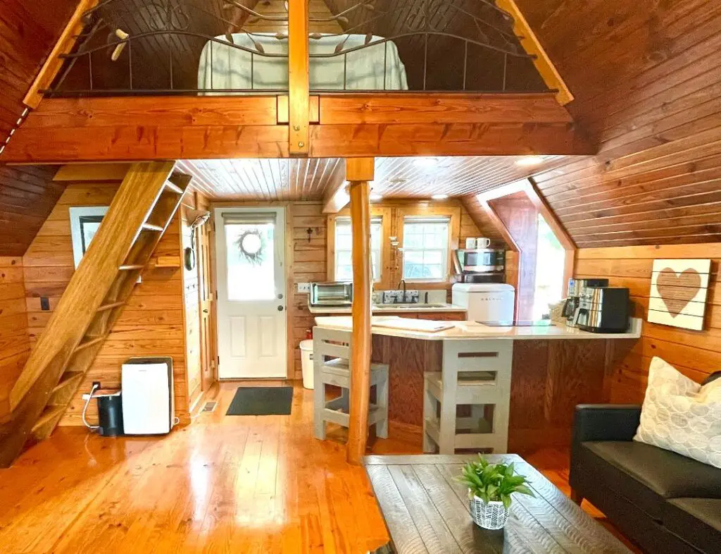 Cozy wooden cabin interior with loft bedroom.