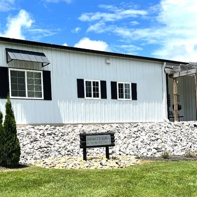 White building with black shutters, daytime.