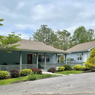 A blue home with a driveway and a garage.