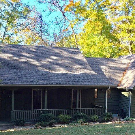 Single-story house with a gabled roof, surrounded by autumn foliage.