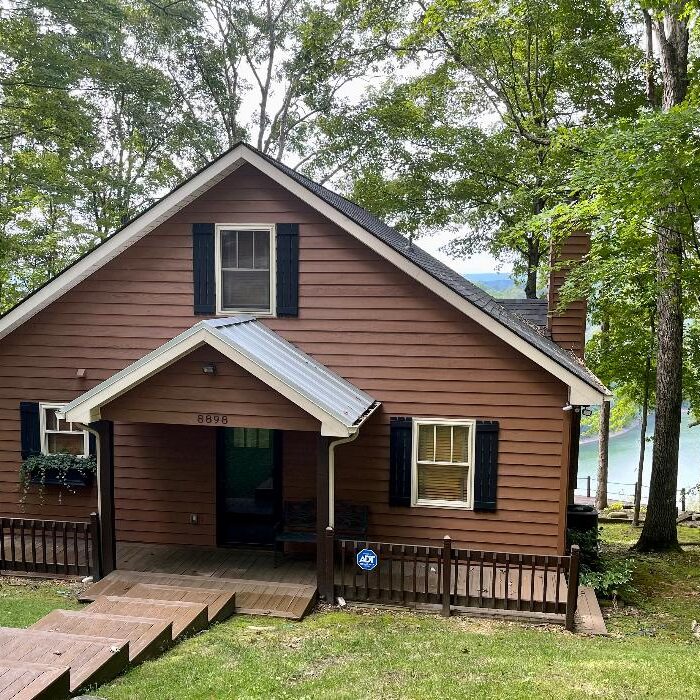 A small cabin in the woods next to a lake.