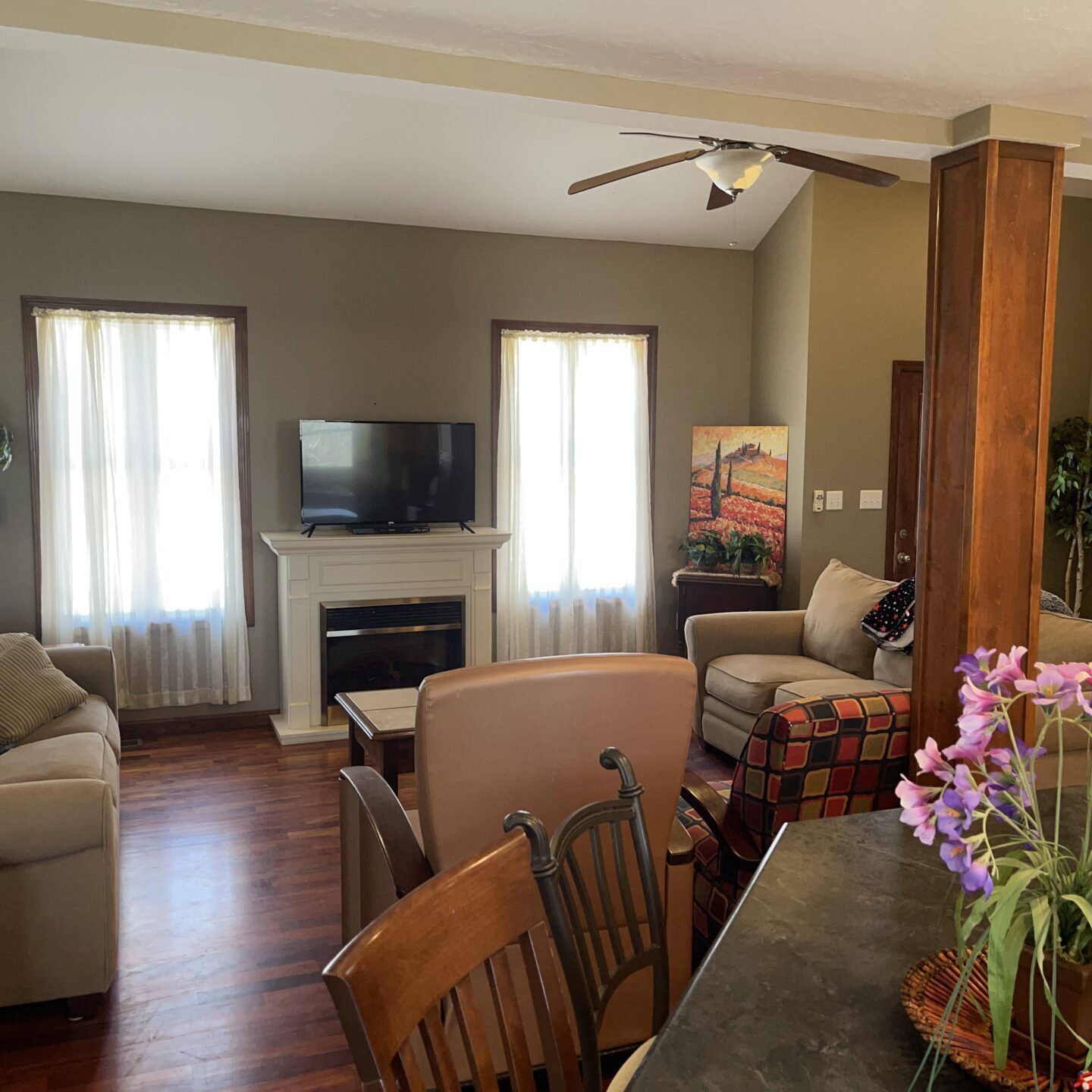 A living room with a table and chairs and a tv.